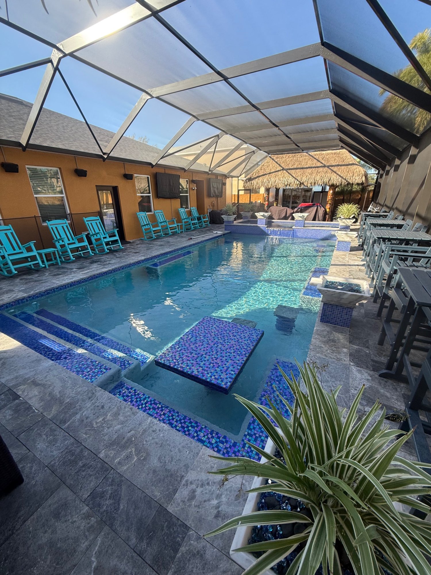 Luxury screened pool with blue mosaic tile